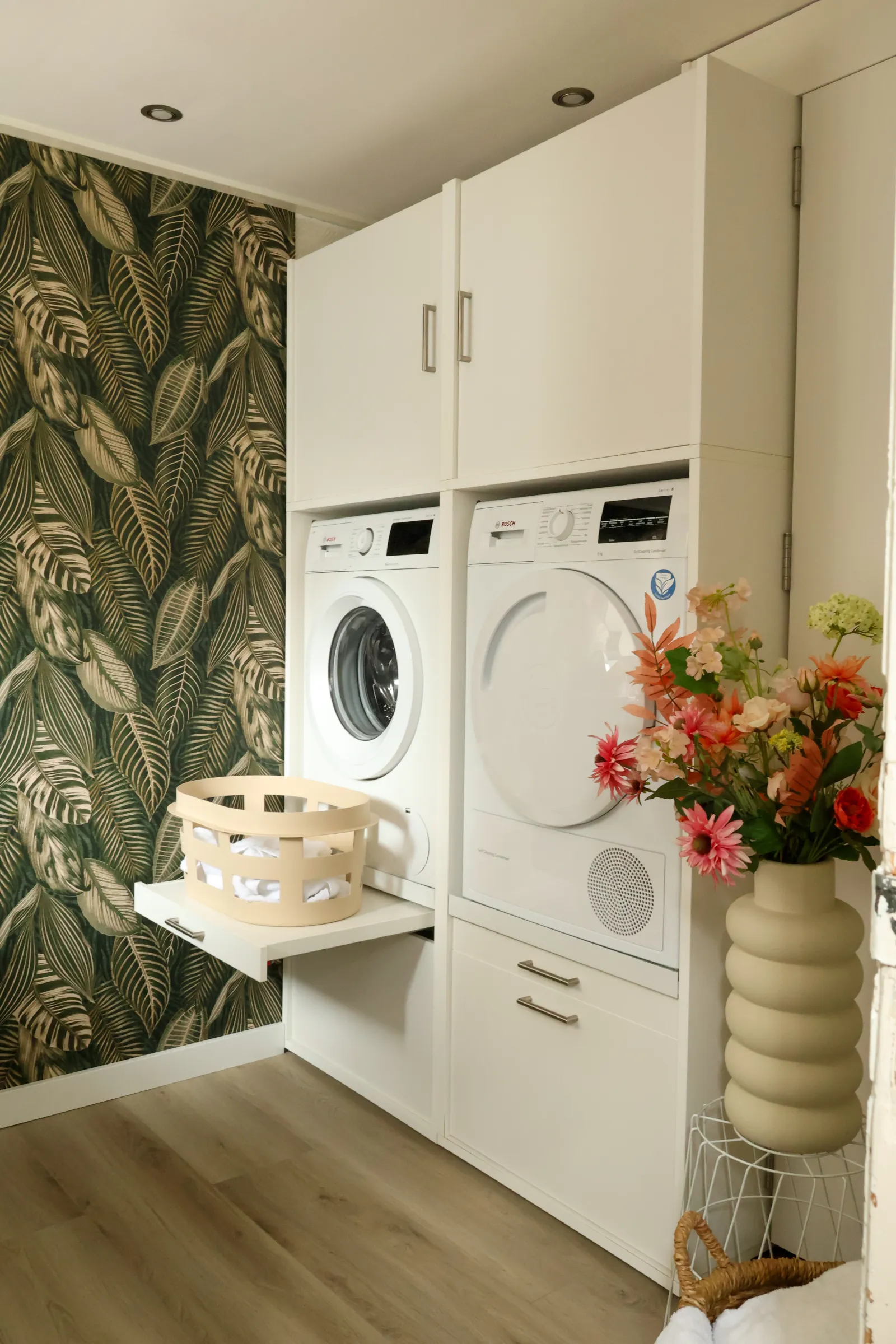 Weisse Washtower Lösung in einem wohnlichen Raum mit Blumentapete und Blumenstrauss