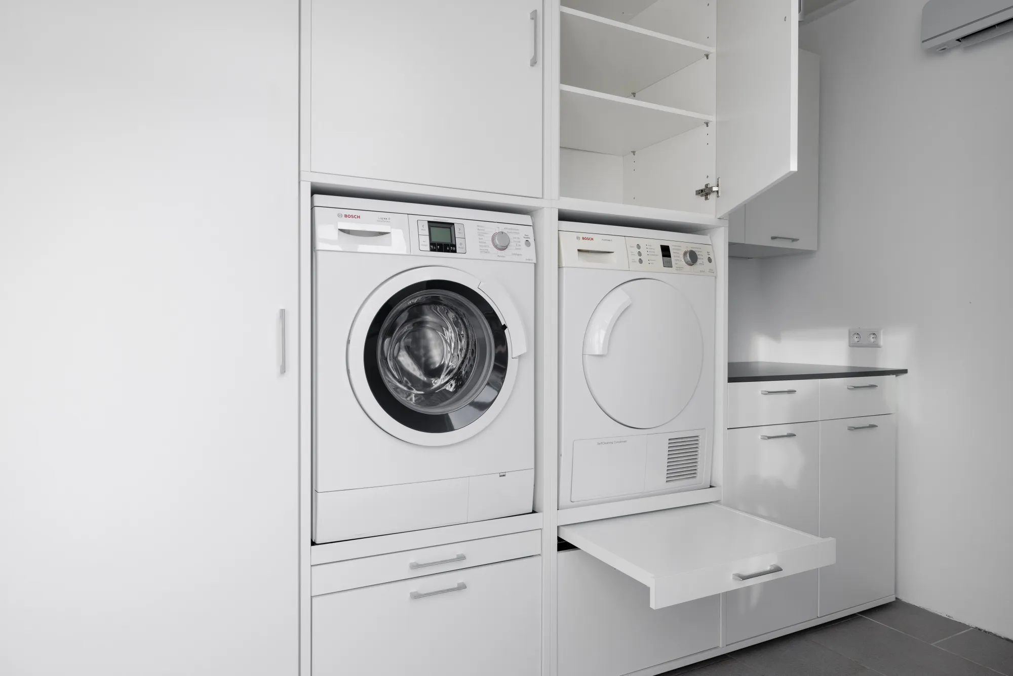 Weisse Washtower Schrankkombination mit geöffneten Schränken und ausziehbarer Ablage